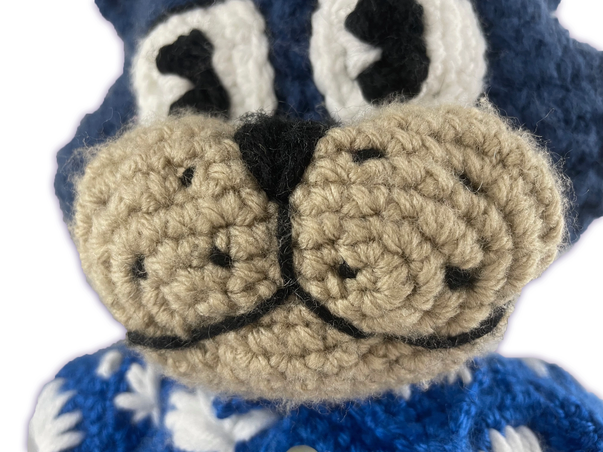 Close-up of crochet Pixie Toontown plush face, handmade blue cat toon features