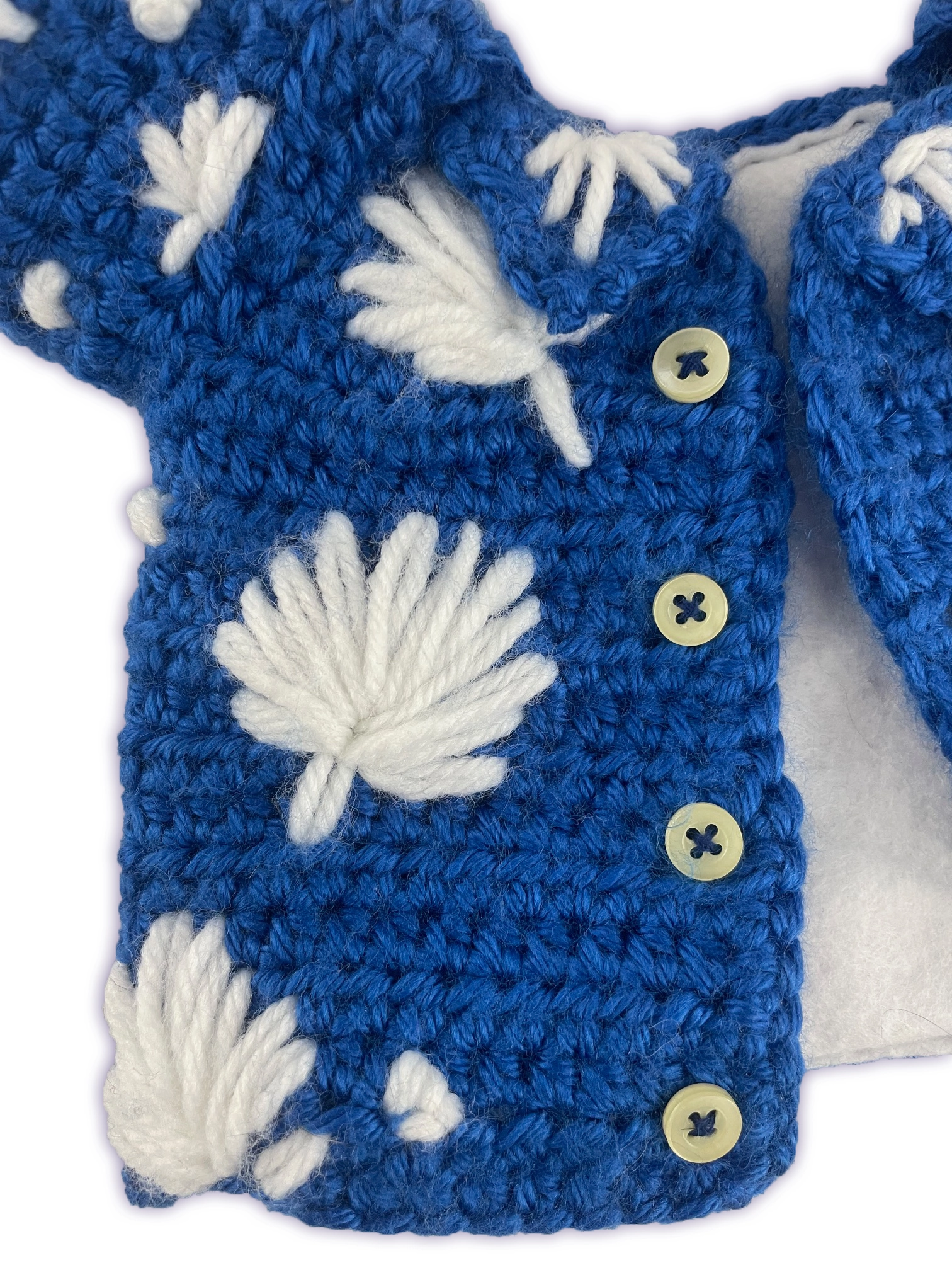 Close-up of crochet Pixie toon shirt, hand-stitched flower detail and functional buttons