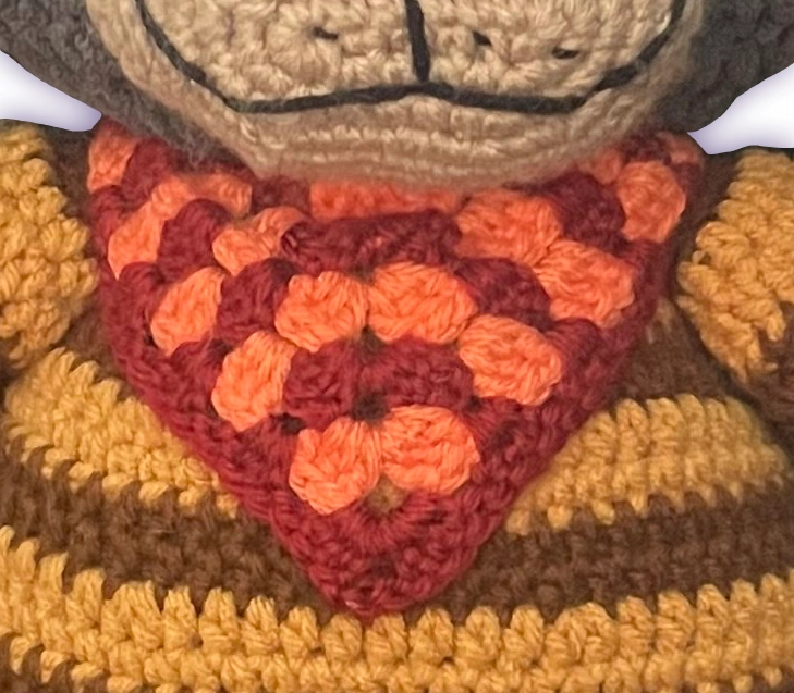 Close-up of Spicy T-Bone crochet toon plush bandana, handmade neck accessory detail