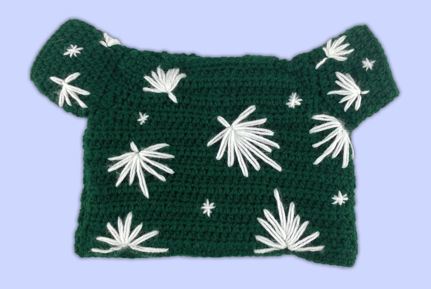 Back view of a custom crocheted shirt for a stuffed animal, featuring decorative yarn-stitched leaves.