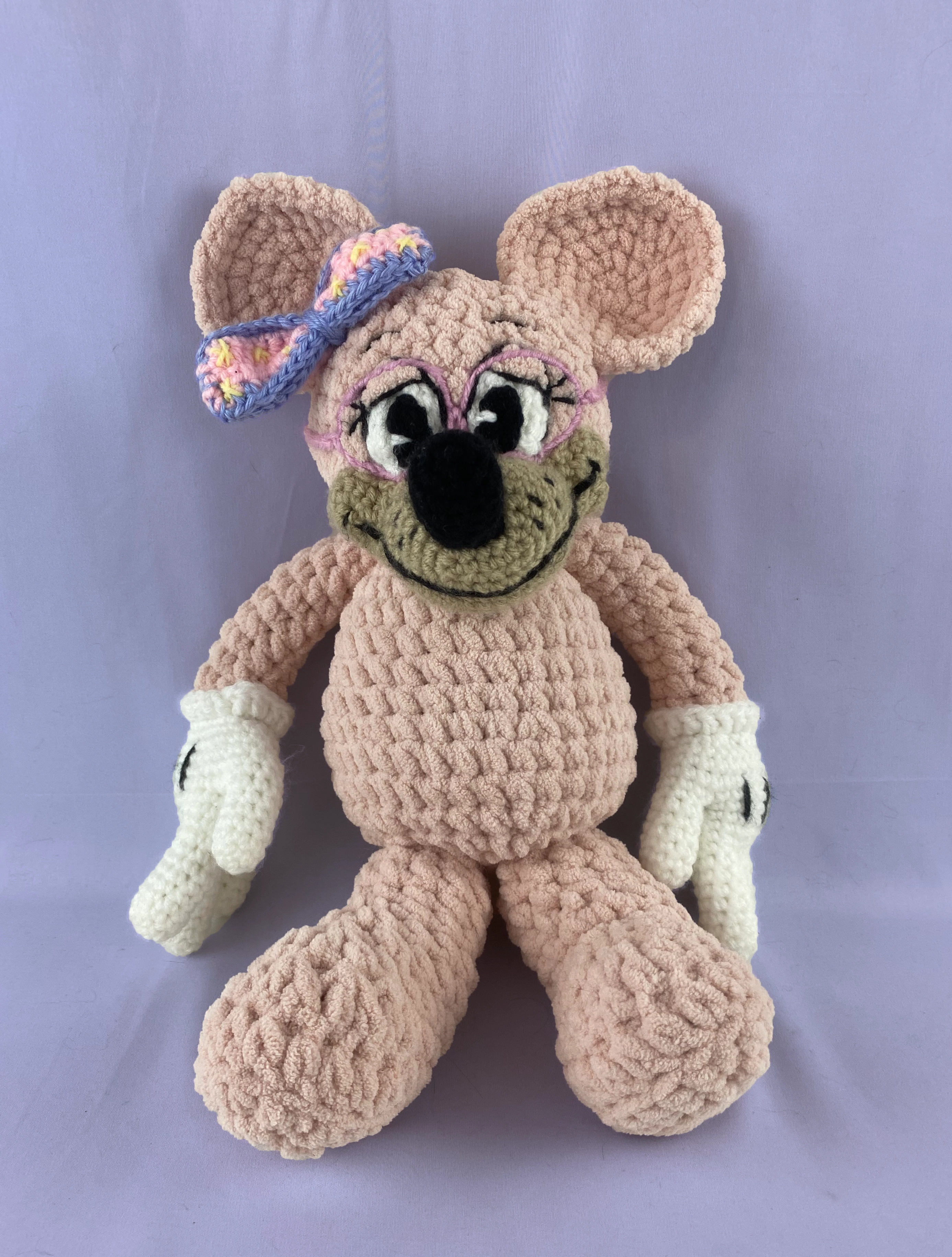 Pink Toontown mouse sitting down in her cute glasses and bow.