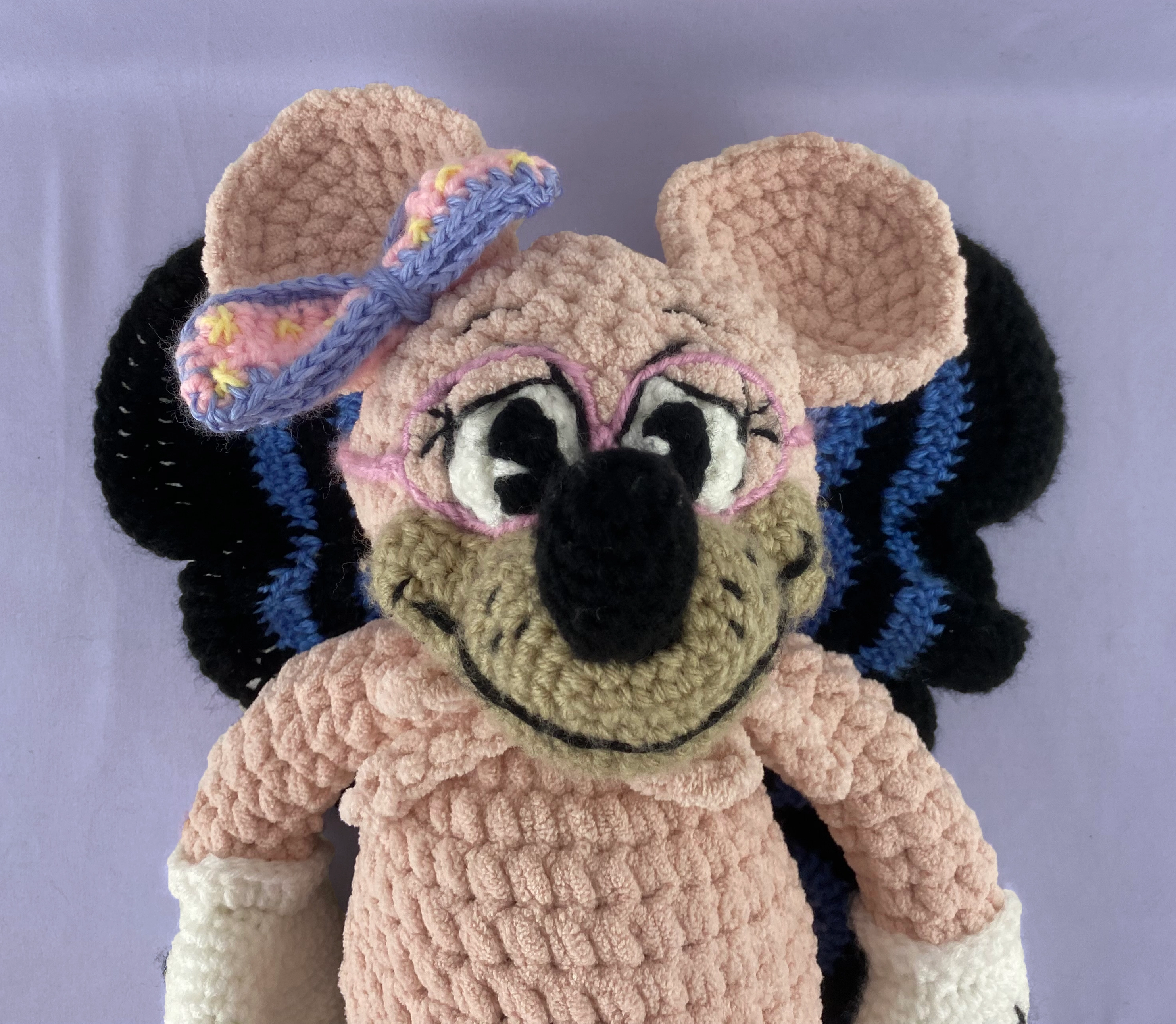 close-up of pink mouse with pink glasses, bow, and butterfly wings