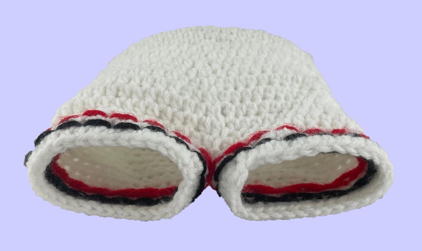 Underview of handmade crochet plush shorts showing interior stitching for the red and grey leg stripes.