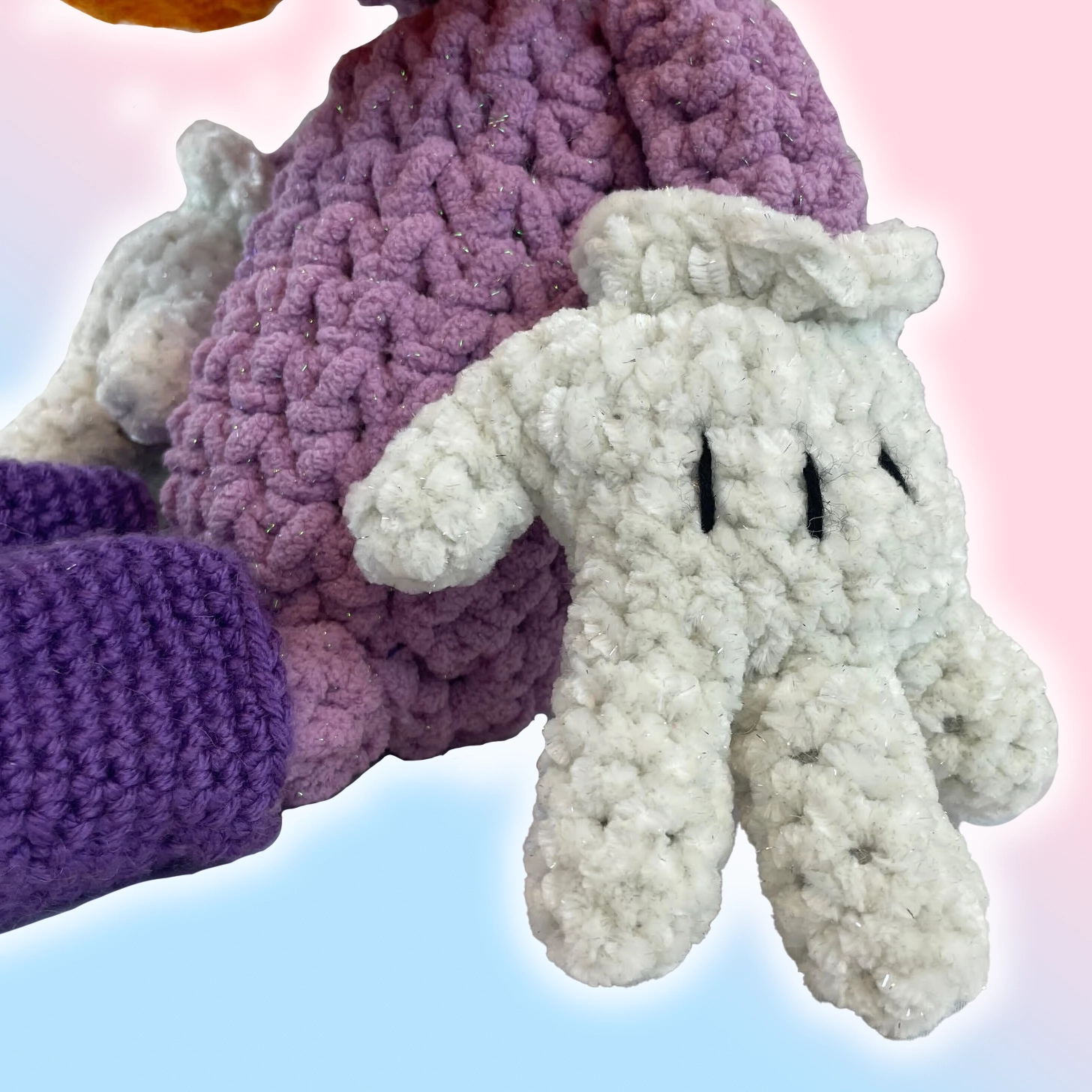 Close-up of cartoon glove hand on crochet Toontown duck plushie with yarn details